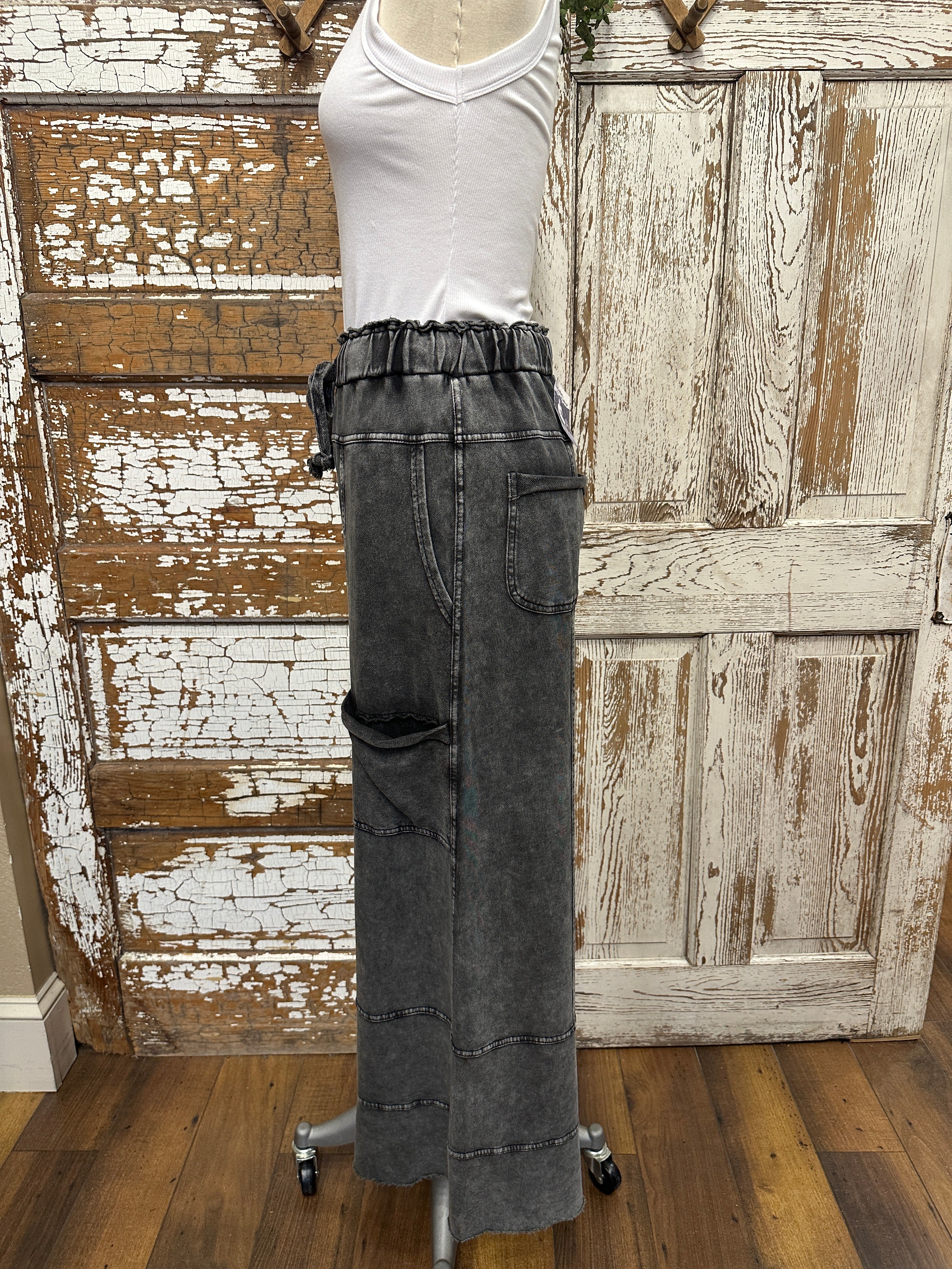 Mannequin wearing a white shirt and leisurewear pants against a rustic wooden background in Springfield, MO boutique