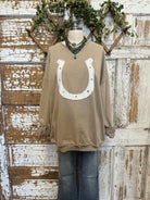 Taupe sweatshirt with a horseshoe design on a mannequin against a rustic wooden background
