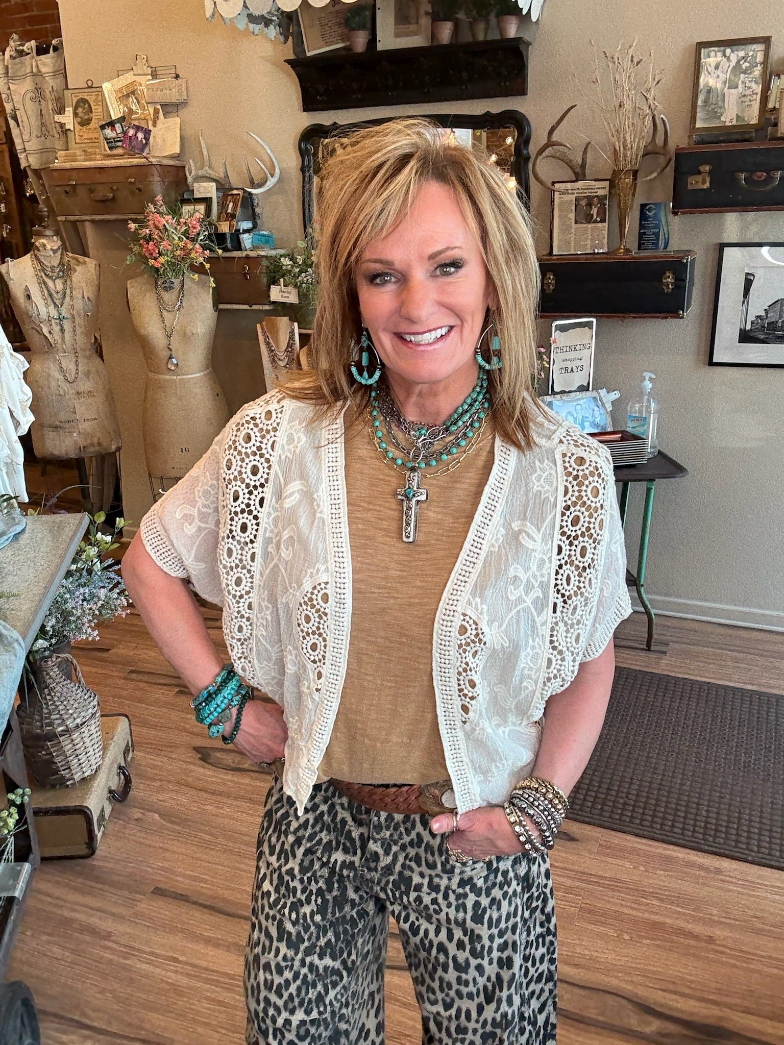 Lu wearing a toffee brown shirt with handmade turquoise jewelry and leopard print barrel jean pants in Lu's Leavenworth, KS boutique