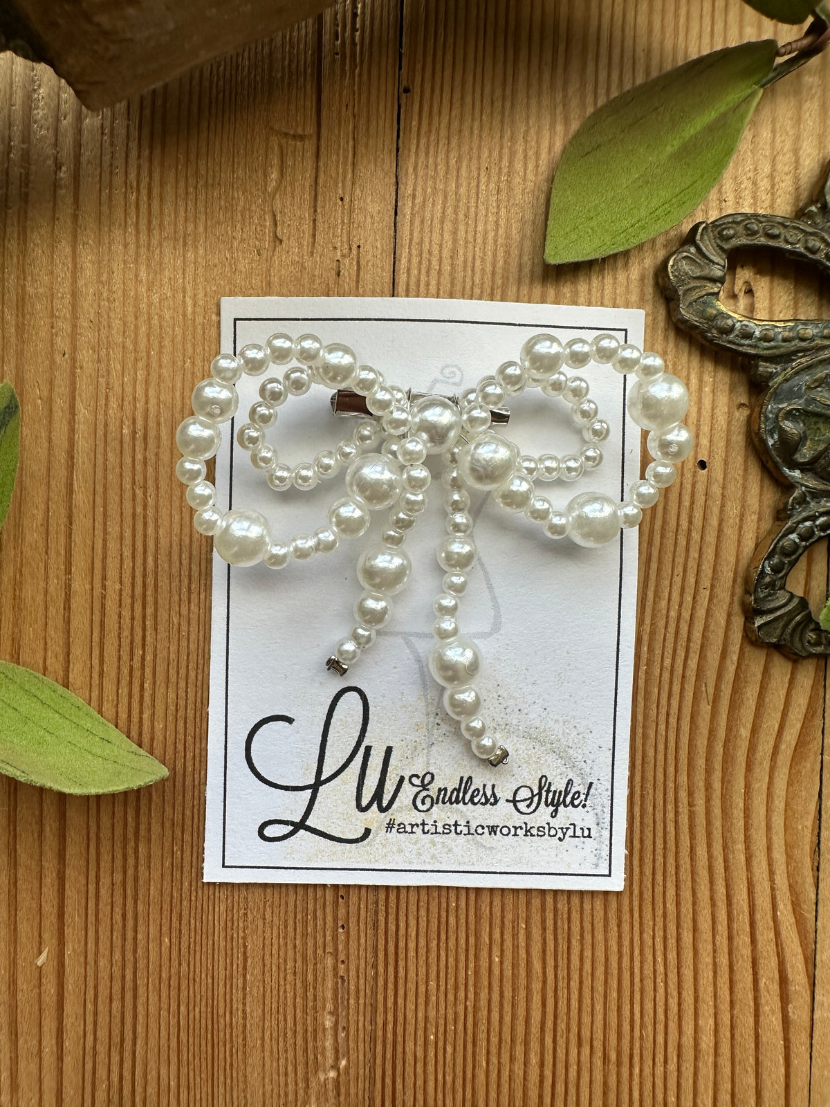 Pearl bow-shaped brooch with dangling pearl tails
