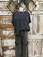 Mannequin wearing grey shirt and boutique clothing pants with handmade jewelry