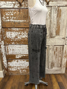 Mannequin wearing a white shirt and leisurewear pants against a rustic wooden background in Springfield, MO boutique