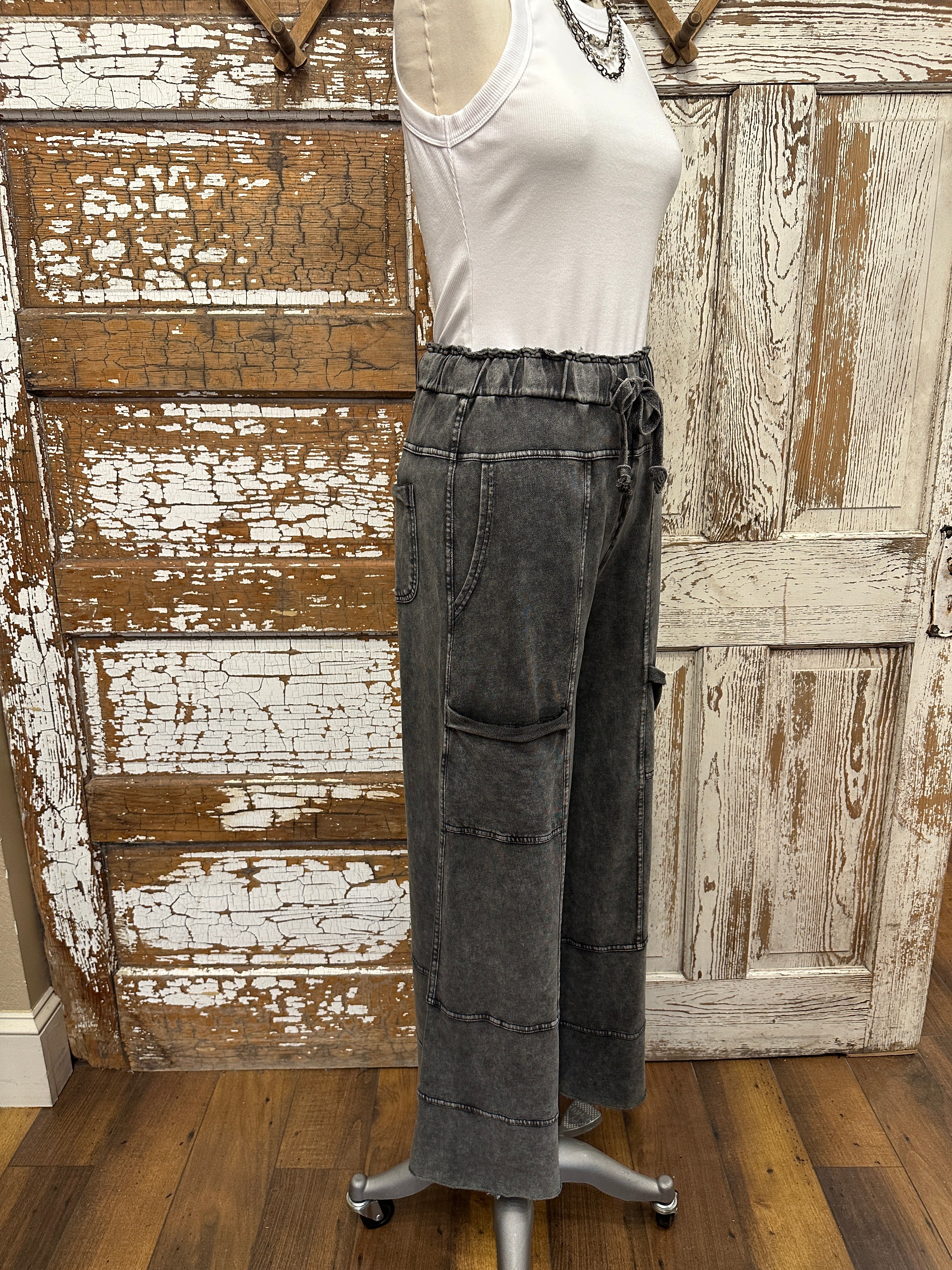 Mannequin wearing a white shirt and leisurewear pants against a rustic wooden background in Springfield, MO boutique