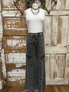 Mannequin wearing a white shirt and leisurewear pants against a rustic wooden background in Springfield, MO boutique with handmade jewelry necklaces