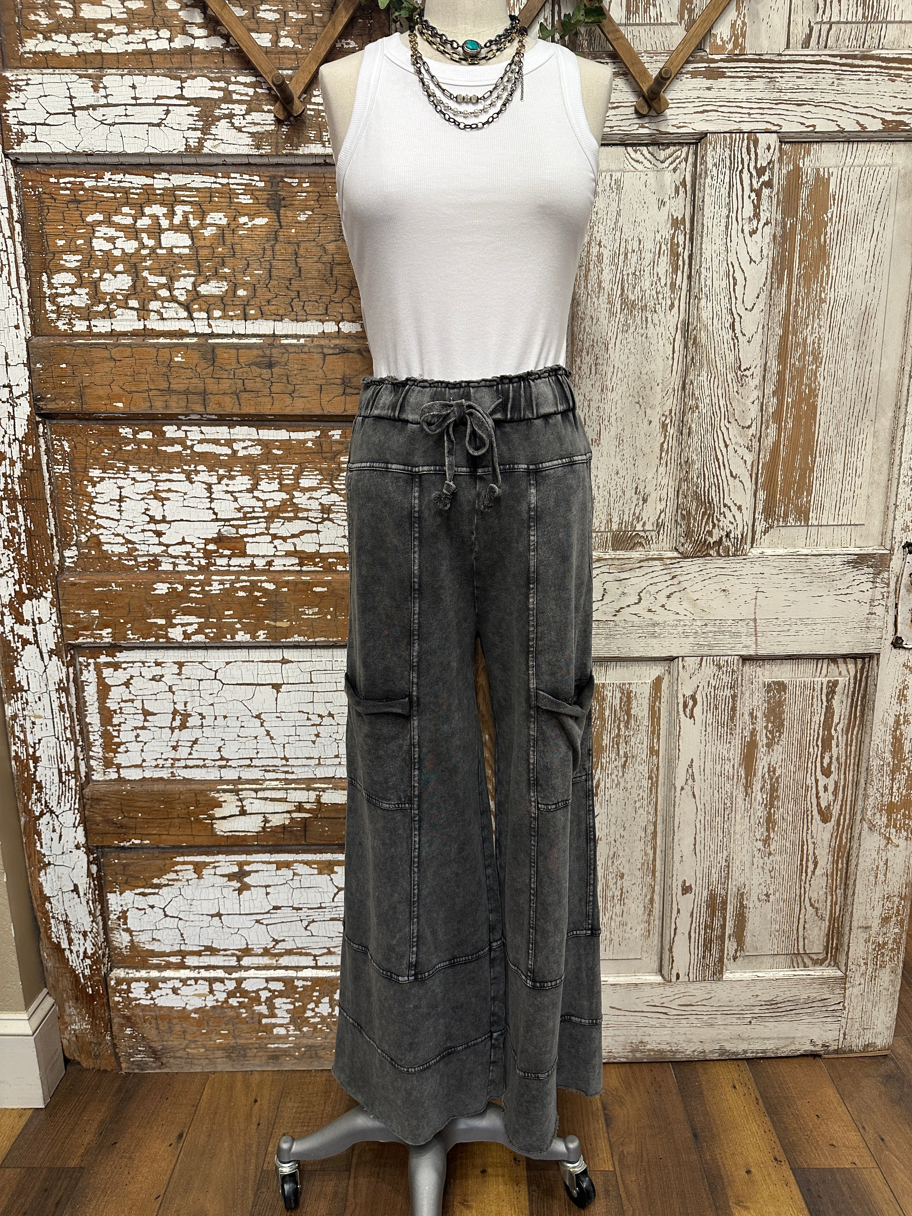 Mannequin wearing a white shirt and leisurewear pants against a rustic wooden background in Springfield, MO boutique