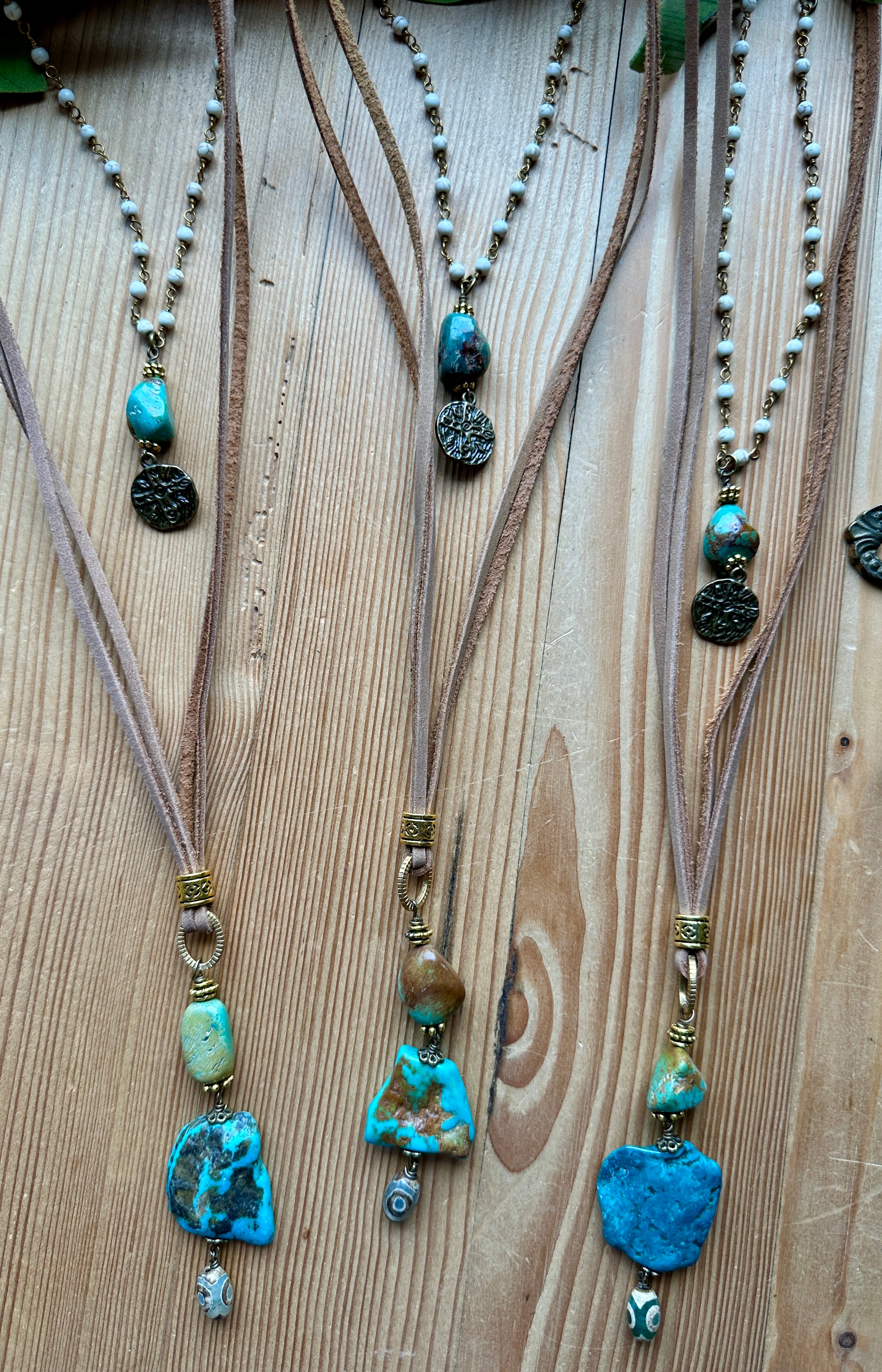 Handmade necklaces with turquoise beads on a wooden surface
