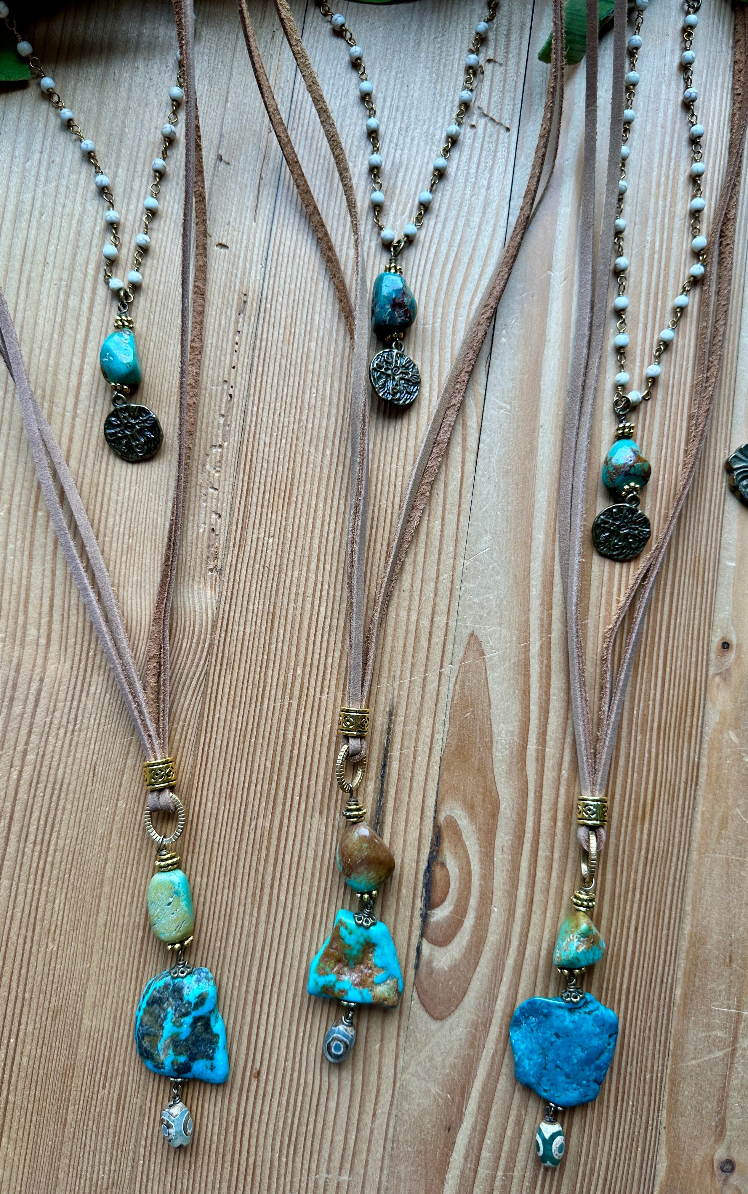 Handmade necklaces with turquoise beads on a wooden surface