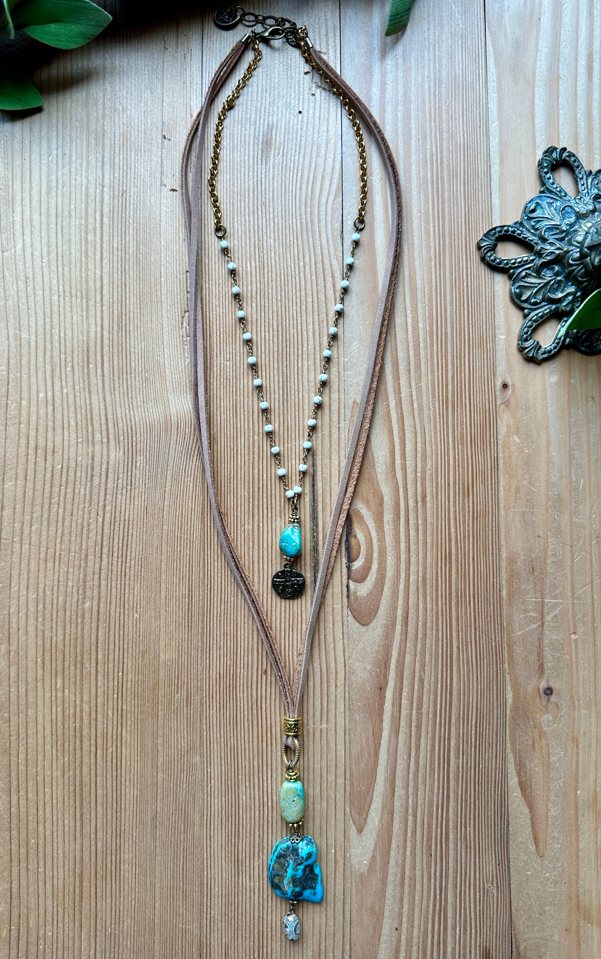 Handmade long double layer necklace with turquoise beads on a wooden surface,