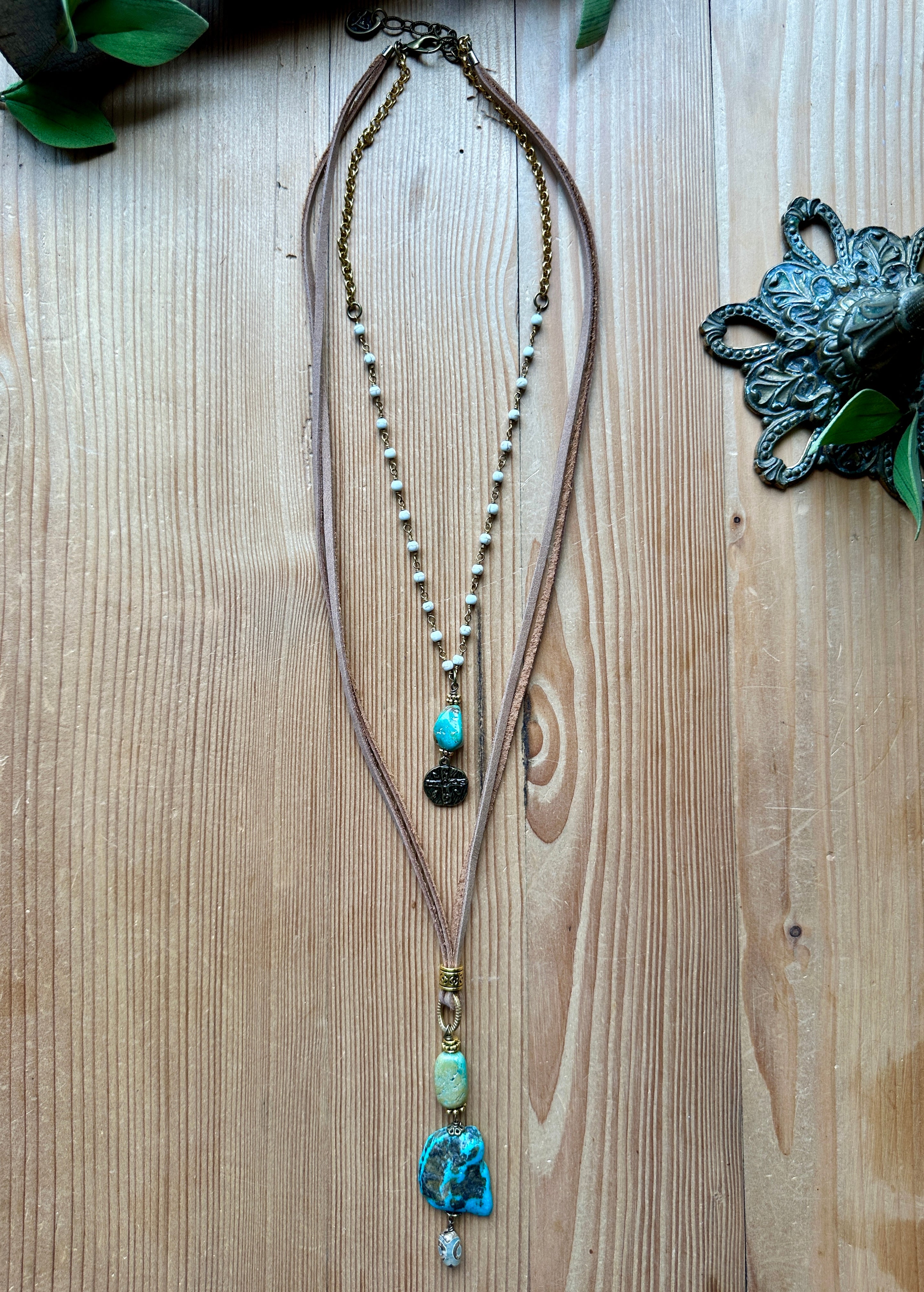 Handmade long double layer necklace with turquoise beads on a wooden surface,