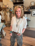 Lu wearing leopard print barrel pants and white lace shrug in Leavenworth, KS boutique
