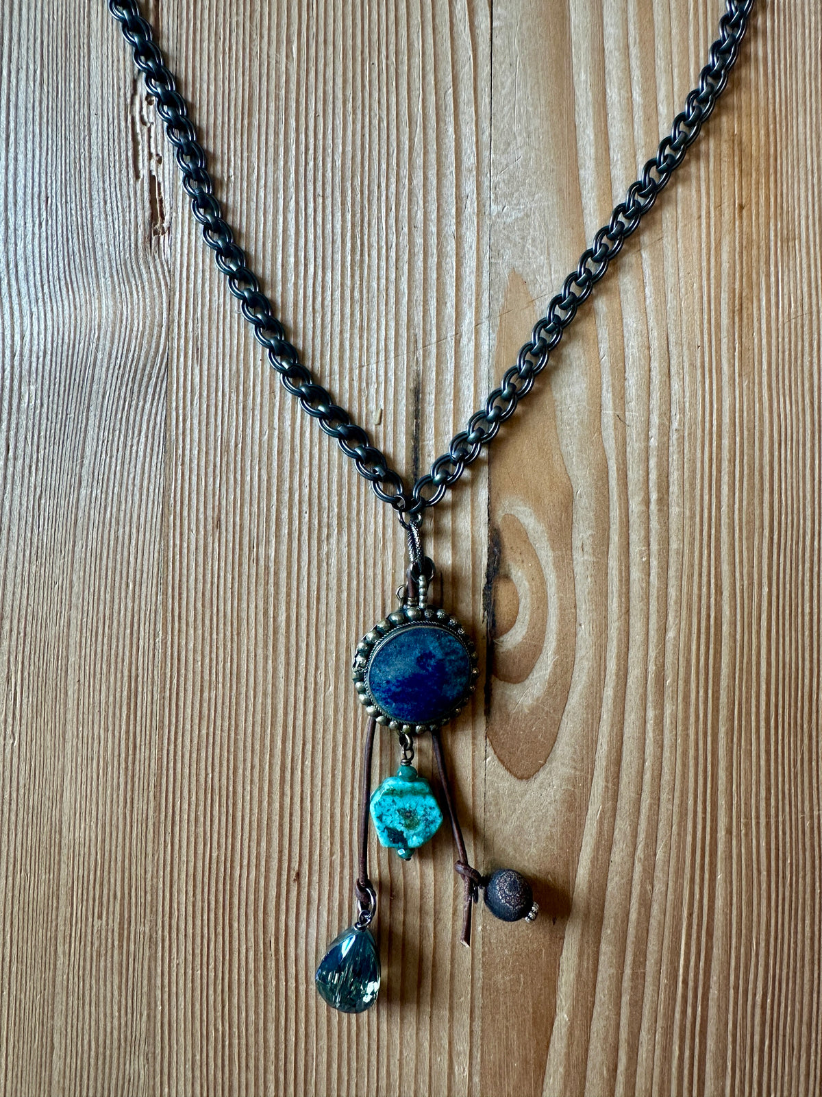 Close-up of lapis lazuli pendant with turquoise and smoky quartz charms