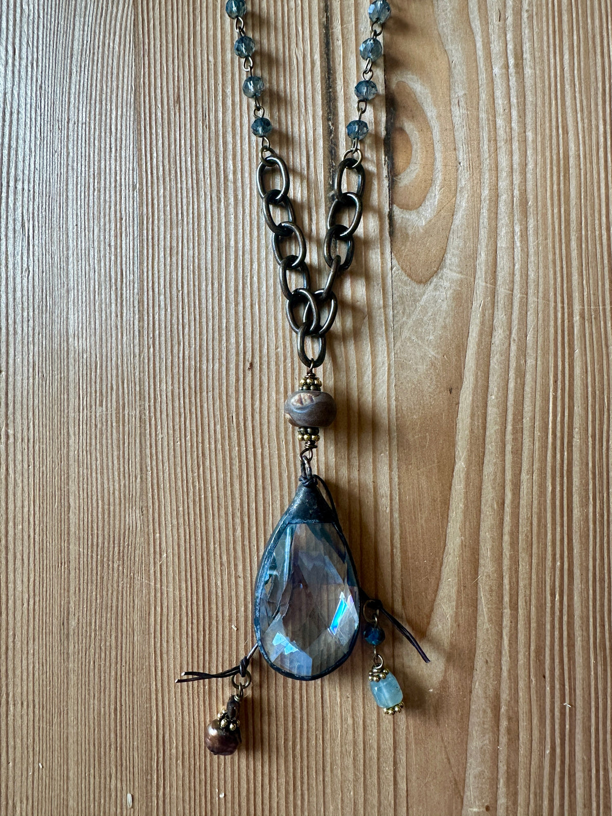 Close-up of faceted crystal teardrop pendant with bead fringe