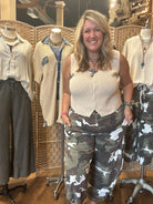 Jennifer wearing army cargo pants and cream vest with handmade jewelry cross necklace