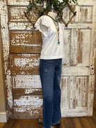 Mannequin wearing a white blouse with lace sleeves and layered handmade necklaces in Leavenworth, KS boutique setting