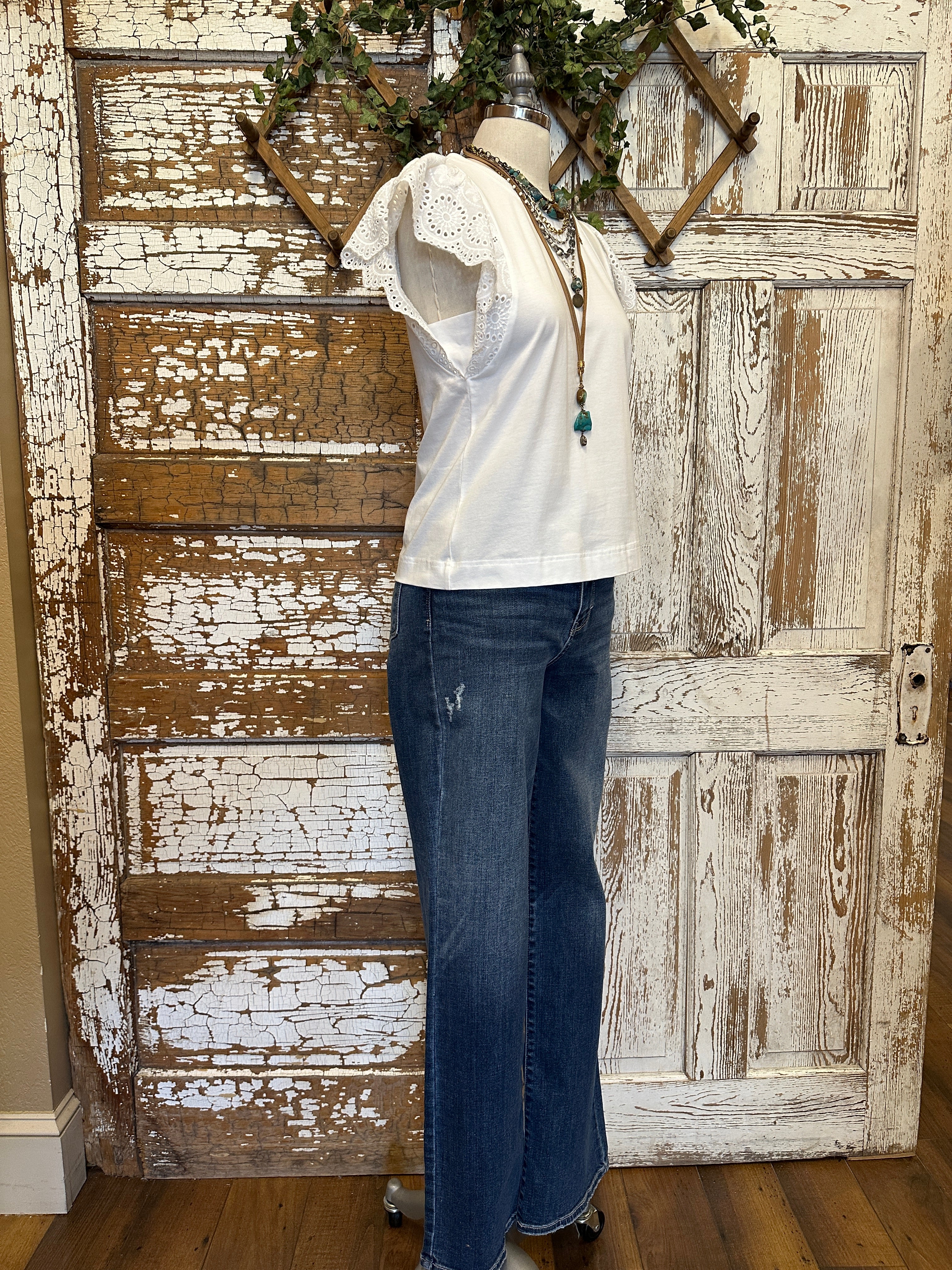 Mannequin wearing a white blouse with lace sleeves and layered handmade necklaces in Leavenworth, KS boutique setting
