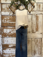 Mannequin wearing a white tank with stitching details and layered handmade necklaces in Leavenworth, KS boutique setting