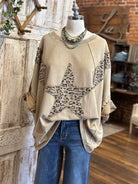 Mannequin wearing a star studded leopard top with leopard print accents and blue jeans in boutique leavenworth, ks
