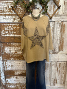 Mannequin wearing a star studded leopard top with leopard print accents and blue jeans in boutique leavenworth, ks