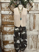 Mannequin wearing army cargo pants and cream vest with handmade jewelry necklace