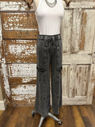 Mannequin wearing a white shirt and leisurewear pants against a rustic wooden background in Springfield, MO boutique 