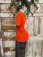 Person wearing a graphic tee shirt orange shirt 