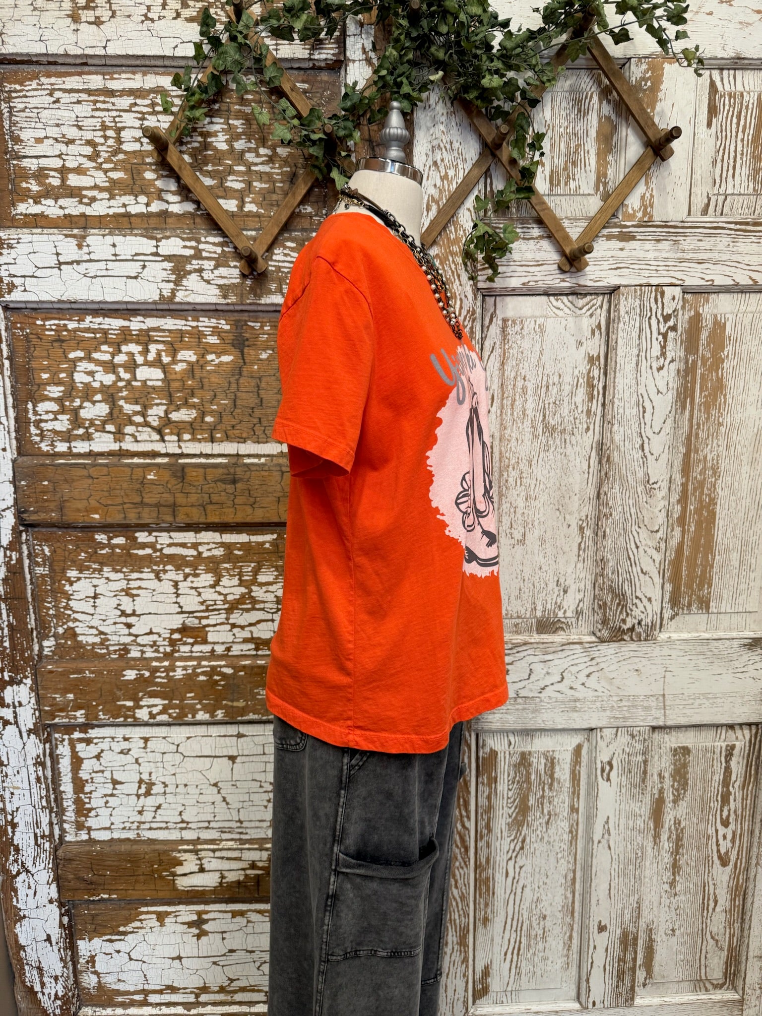 Person wearing a graphic tee shirt orange shirt 