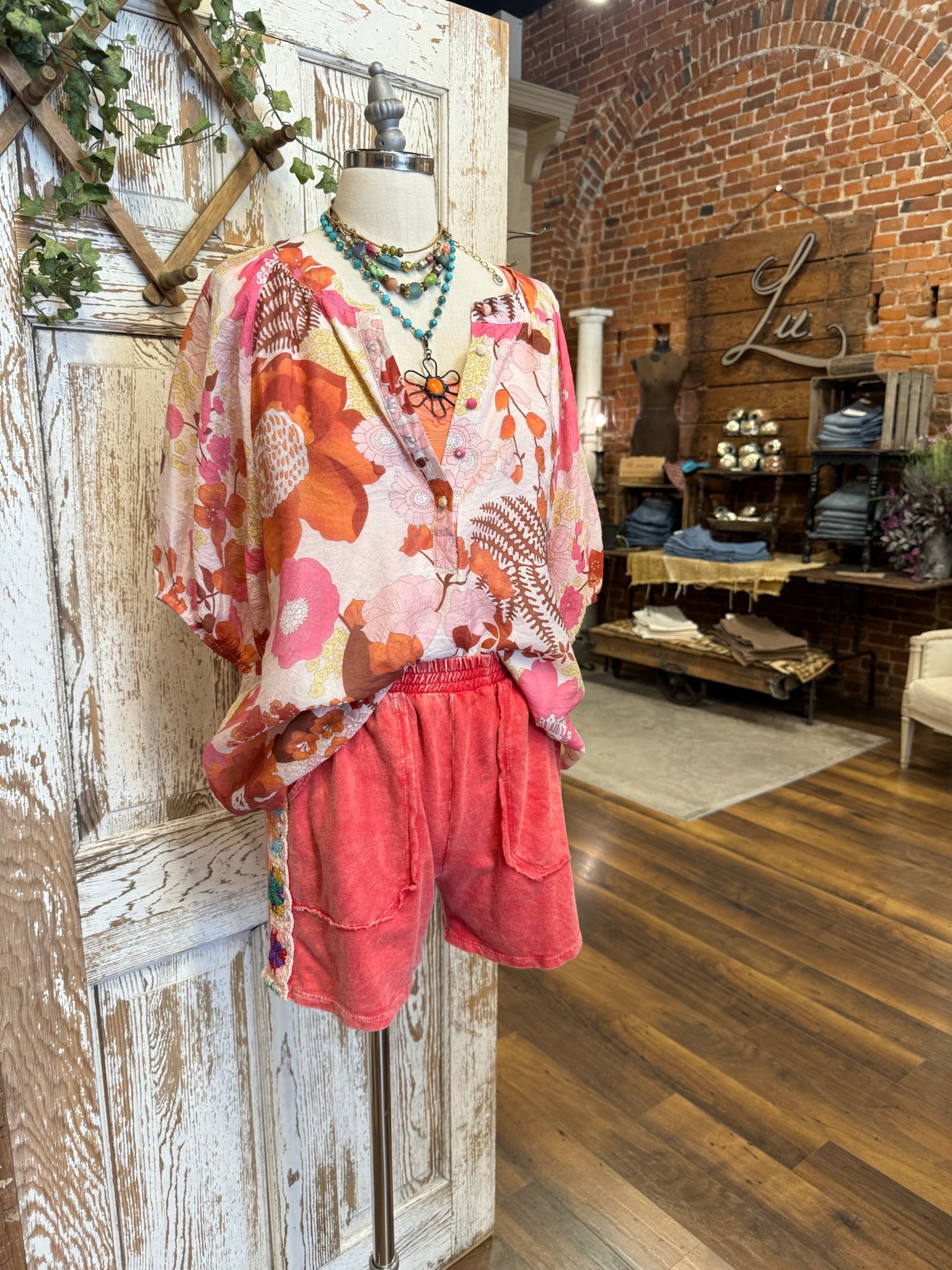 Mannequin wearing a poppy red matching leisure set with floral top in Leavenworth, KS boutique 