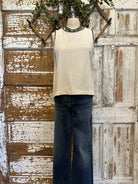 Mannequin wearing a Ivory Sleeveless Tank with Black Whipstitch Trim with layered handmade necklaces in Leavenworth, KS boutique setting
