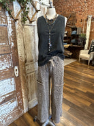 Mannequin wearing charcoal tank and patterned leopard print pants against a rustic boutique springfield, mo