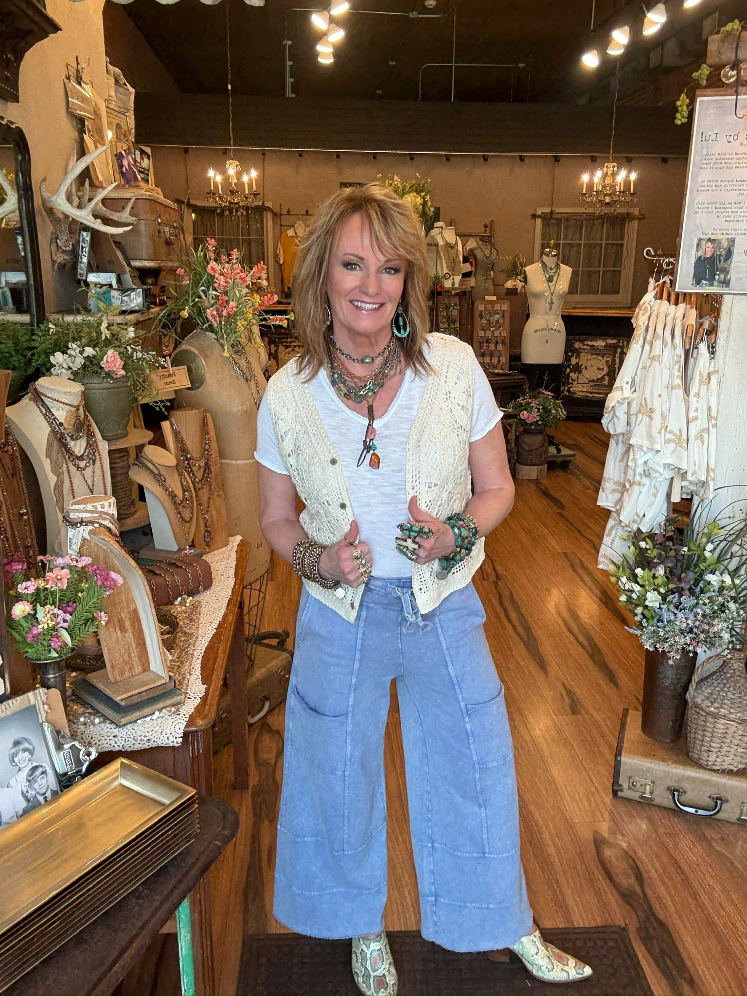 Lu standing in Leavenworth boutique store in leisurewear pants and crochet vest with handmade jewelry 