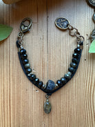 Sacred Ground Black Tourmaline Drift Bracelet with raw tourmaline center, faceted gemstone rondelles, pyrite, black leather band, heart clasp, and Lu medallion