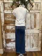 Mannequin wearing a white blouse with lace sleeves and layered handmade necklaces in Leavenworth, KS boutique setting