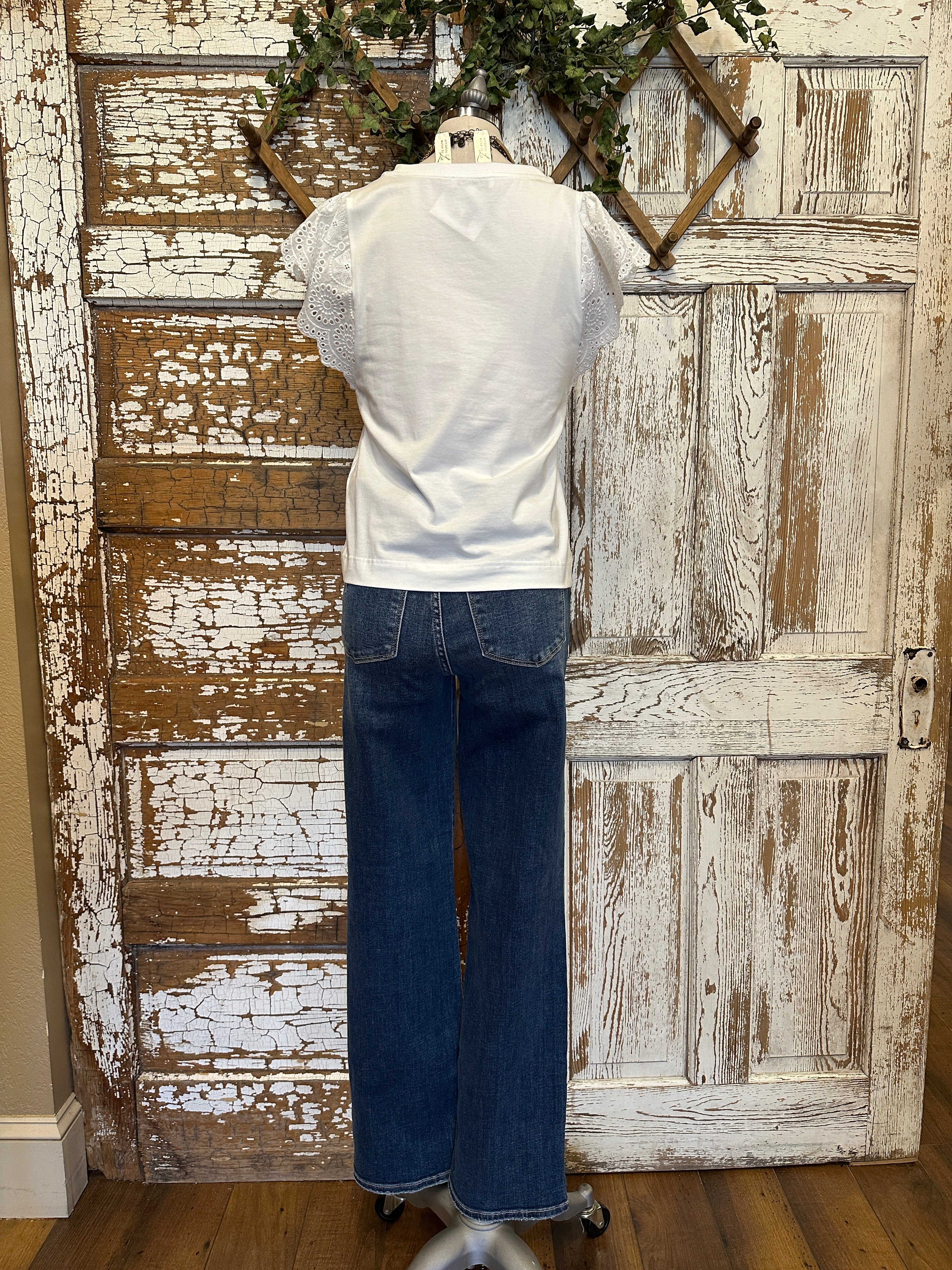 Mannequin wearing a white blouse with lace sleeves and layered handmade necklaces in Leavenworth, KS boutique setting
