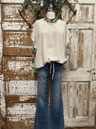 Mannequin wearing a boutique clothing top and jean pants with handmade jewelry designs in boutique near me 