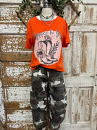 Mannequin wearing a plaid shirt, orange graphic t-shirt, and camouflage pants in a Leavenworth, KS boutique