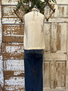 Mannequin wearing a white tank with stitching details and layered handmade necklaces in Leavenworth, KS boutique setting