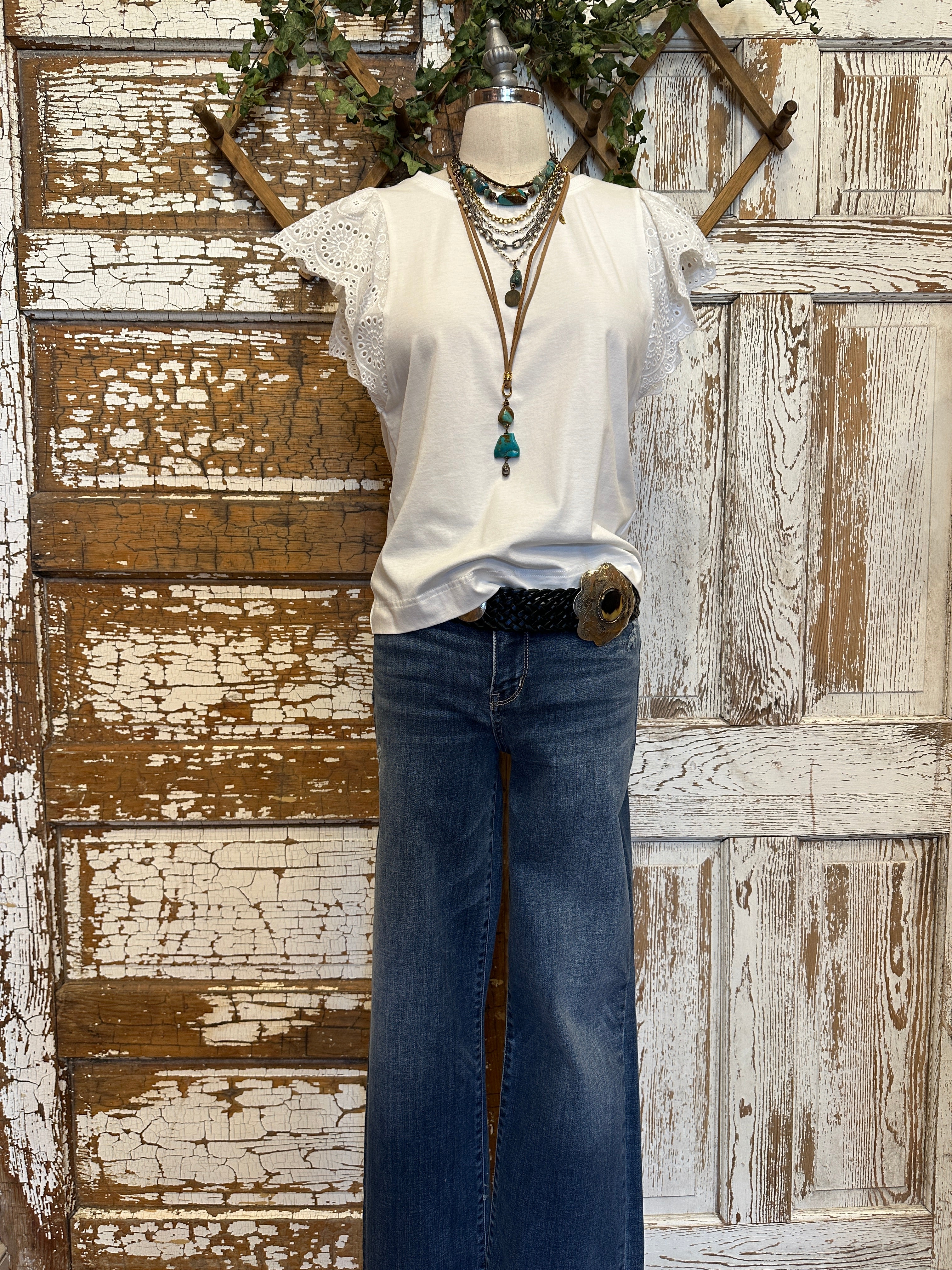 Mannequin wearing a white blouse with lace sleeves and layered handmade necklaces in Leavenworth, KS boutique setting
