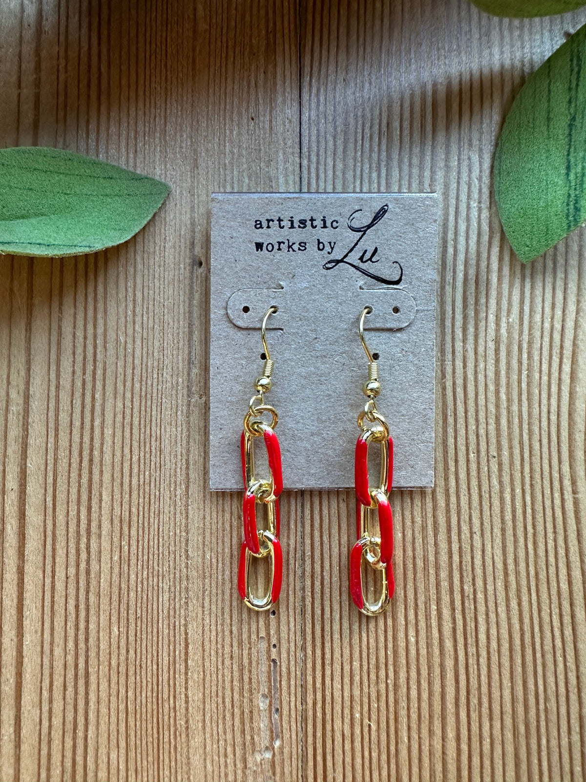 Red enamel and gold paperclip chain drop earrings on an Artistic Works By Lu earring card