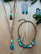Handmade turquoise jewelry set including necklaces and earrings on a wooden surface