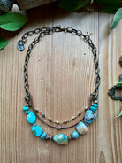 Handmade necklace with turquoise beads, leather and chain on a wooden surface