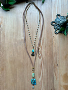 Handmade long double layer necklace with turquoise beads on a wooden surface,
