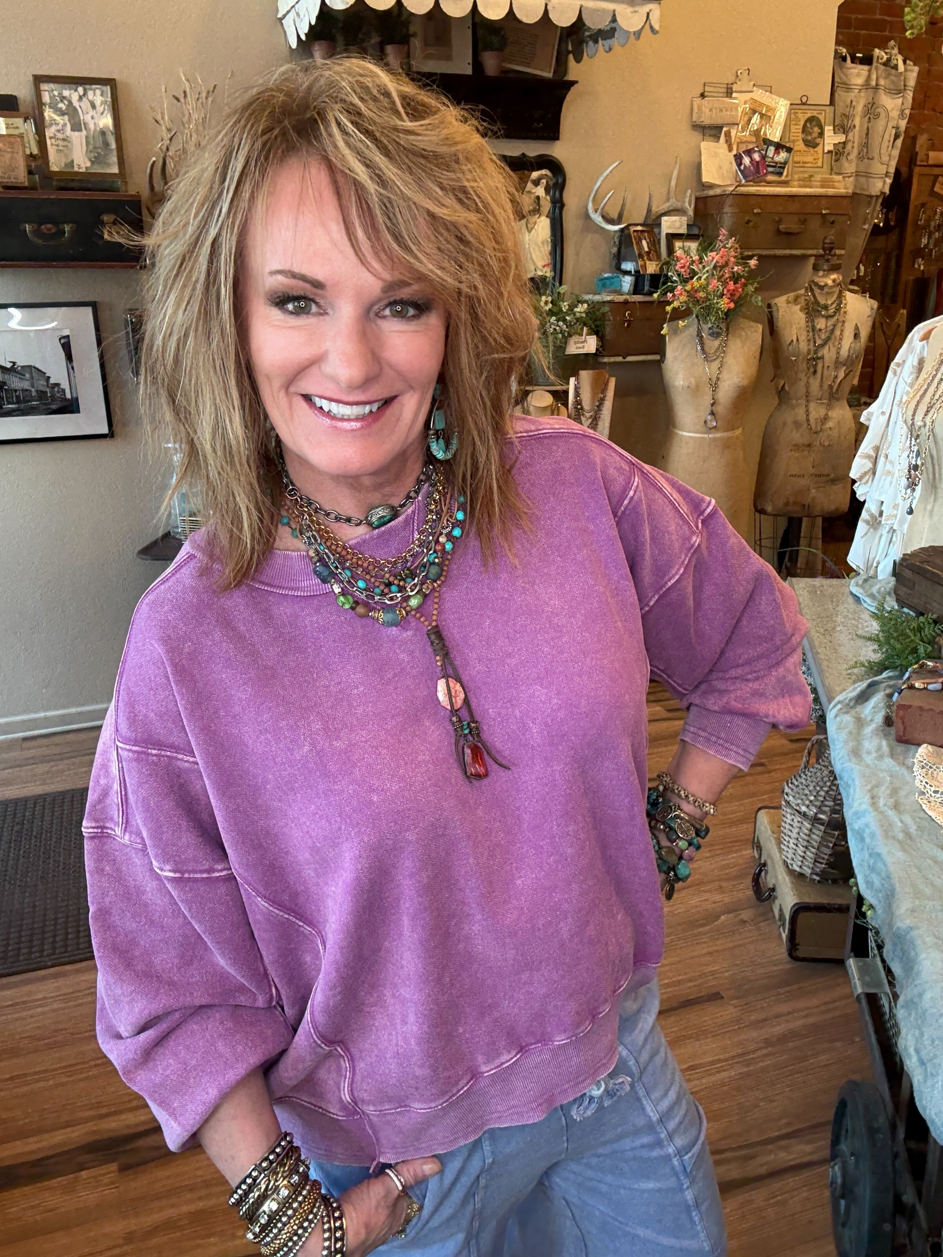 Lu wearing a purple sweater and periwinkle loungewear and leisurewear pants in Leavenworth, KS clothing boutique with handmade jewelry 
