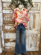 Mannequin wearing a floral blouse and jeans with handmade jewelry layers 
