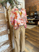 Mannequin wearing a floral blouse and leisurewear pants with handmade jewelry layers 