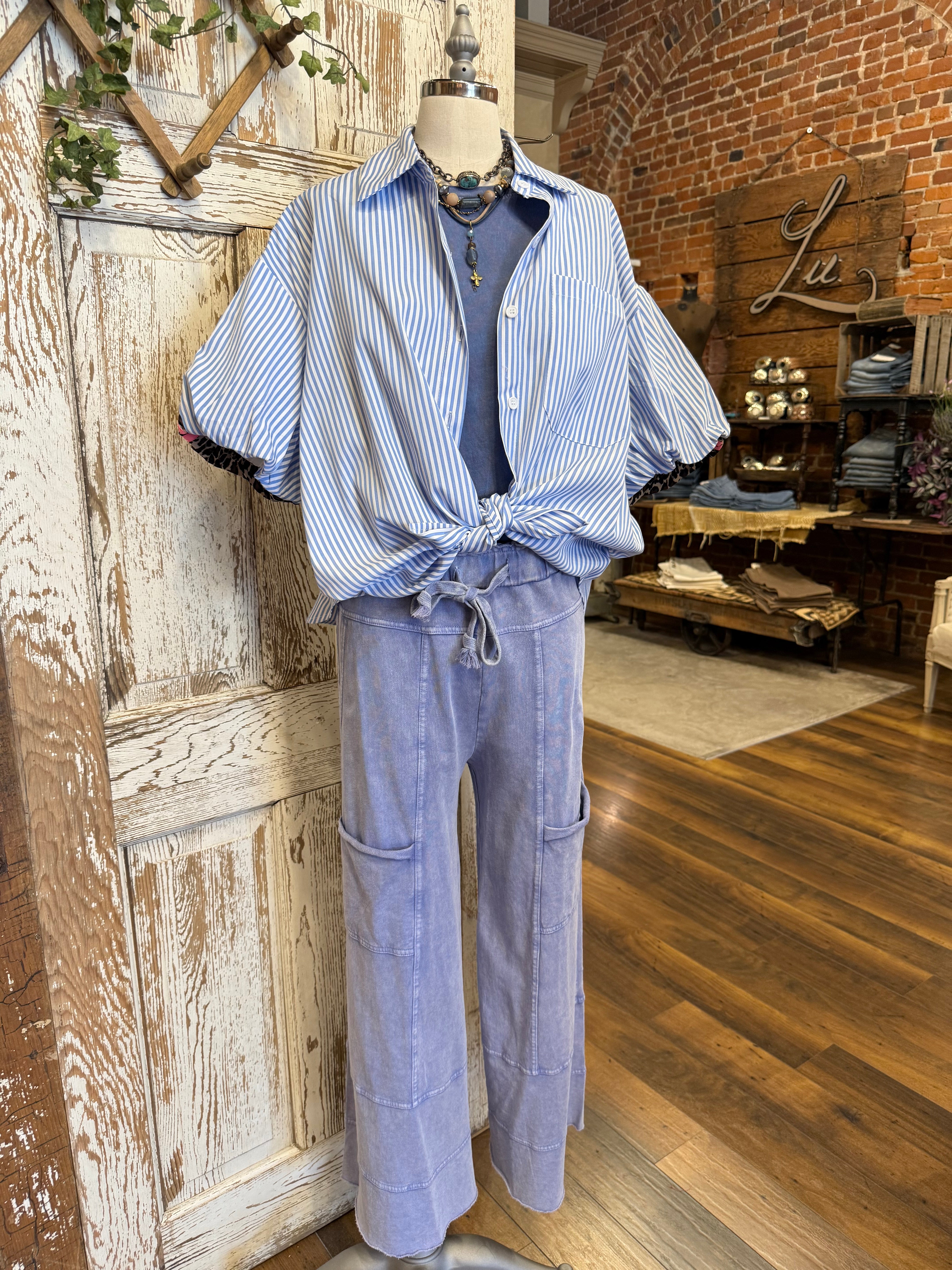 Mannequin wearing a blue striped shirt with pink and leopard detail and handmade jewelry and loungewear pants in Springfield, MO boutique