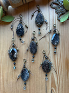Sacred Ground Fossil Coral Pendant Charms with faceted dark fossil coral stones, pyrite, brown cord wrap, black bead, crystal drop, and brass lobster clasps