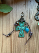 Wild Eden Verdigris Cross Pendant Charm with patina crucifix cross, tiger eye and blue gemstone dangles, leather cord, rhodonite beads, and brass lobster clasp