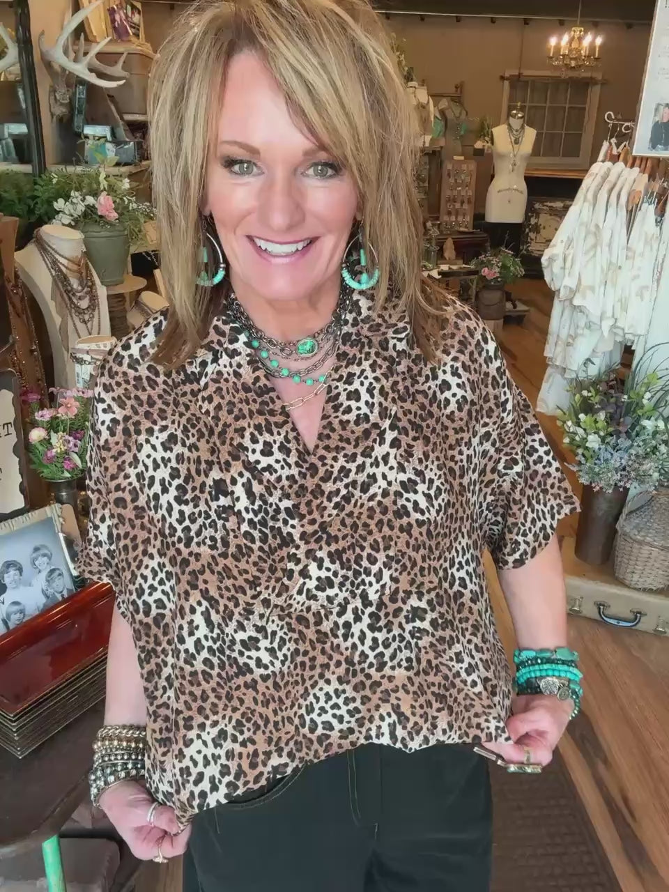 Lu wearing leopard print blouse and turquoise jewelry in Leavenworth, KS boutique