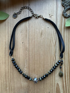 Sacred Ground Midnight Sheen Leather Necklace with faceted dark beads, crystal centerpiece, side stone drop, and black leather straps