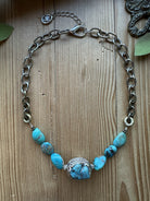 Sacred Ground Turquoise Nugget Necklace with seven turquoise nuggets, ornate silver-tone centerpiece, and mixed-metal chain